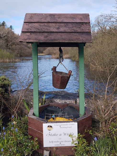 im Hintergrund ein See davor ein Brunnen