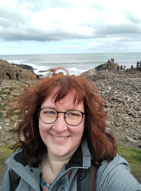 vorne eine Frau  hinten Felsen