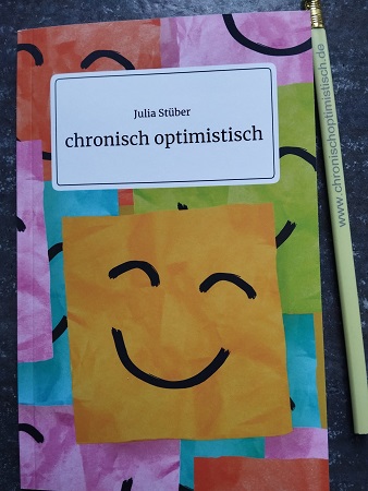 Buch mit einem bunten Cover und einem lachenden Smiley