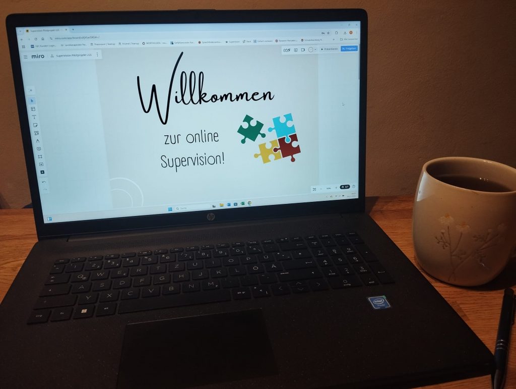 Laptop mit dem Bild "Willkommen zur online Supervision", daneben eine große Tasse Tee