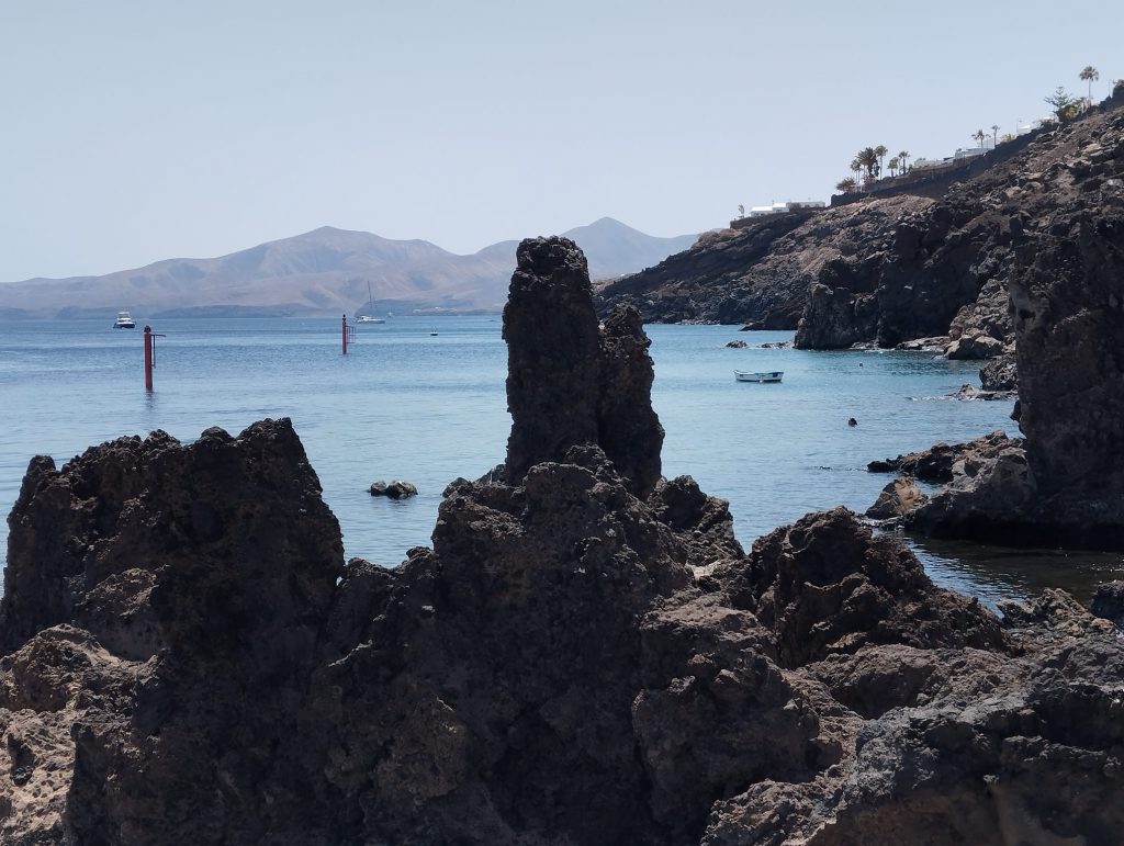 Lavafelsen im Vordergrund und rechts, dahinter Meer