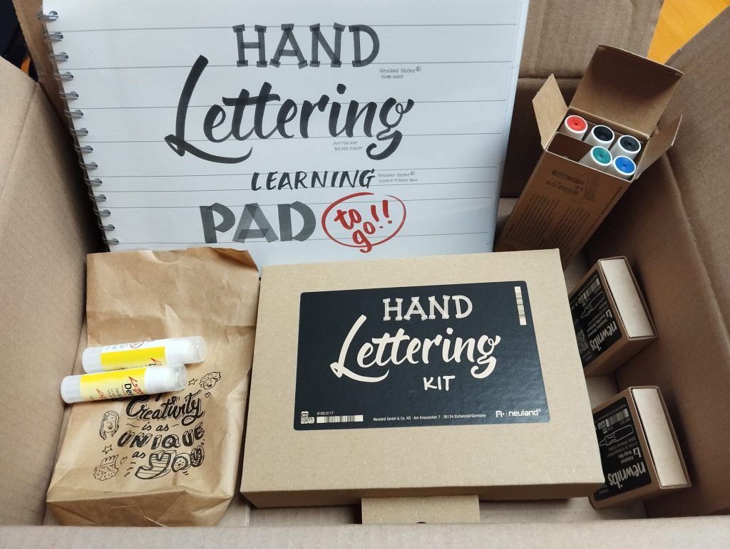 Karton mit Stiften, Kleber, Hand Lettering Kit