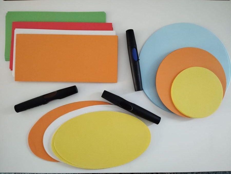 drei Stifte und rechteckige, runde und ovale bunte Blätter